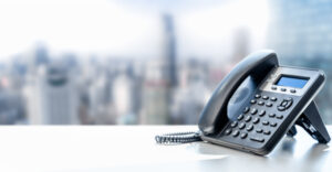 telephone with VOIP on white table on blurred city background. customer service support, call center concept. Modern Phone VoIP. Communication support, call center and customer service help desk