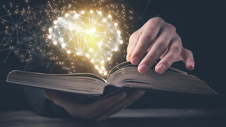 Man holding book with a human glowing brain. AI boo historical