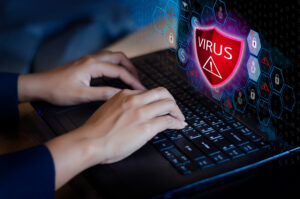 Press enter button on the keyboard computer Protective shield virus red Exclamation Warning Caution Computer in dark with word virus data wipers 