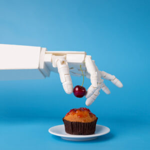 Chef robotic assistant in kitchen technology. Robot hand decorating sweet cupcake with fresh cherry, blue background